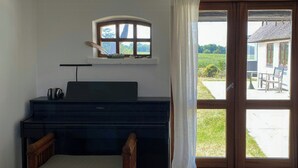 Ett rum med en säng, ett skrivbord med en stol, ett fönster med gardiner och utsikt över omgivningen.