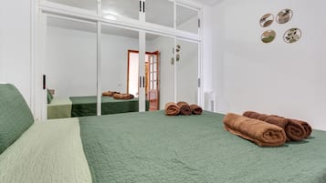 Une chambre d’hôtel avec deux lits, un grand miroir et une armoire à porte coulissante.