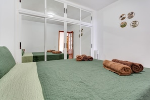 Una camera d'albergo con due letti, uno specchio grande e un armadio con ante scorrevoli.