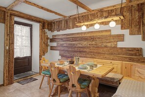 Un interior rústico de madera con una mesa de comedor, sillas y un banco.