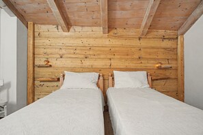 Habitación con dos camas, cabecera de madera y lámparas de noche.