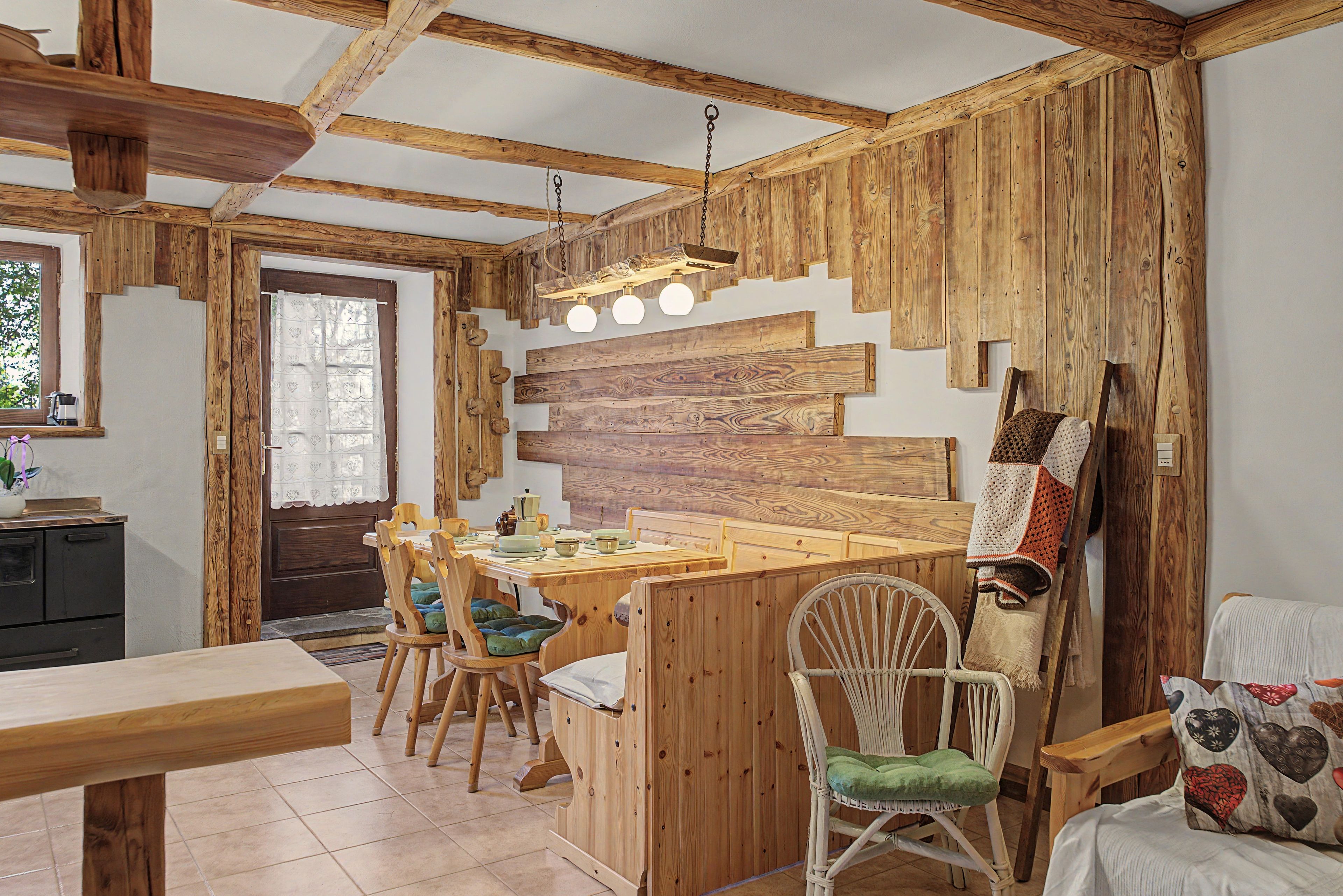Ein rustikales Interieur mit einem Holztisch, Stühlen und einer Küchenzeile.