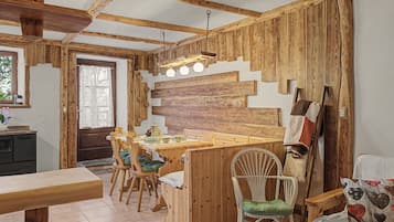 Ein rustikales Interieur mit einem Holztisch, Stühlen und einer Küchenzeile.