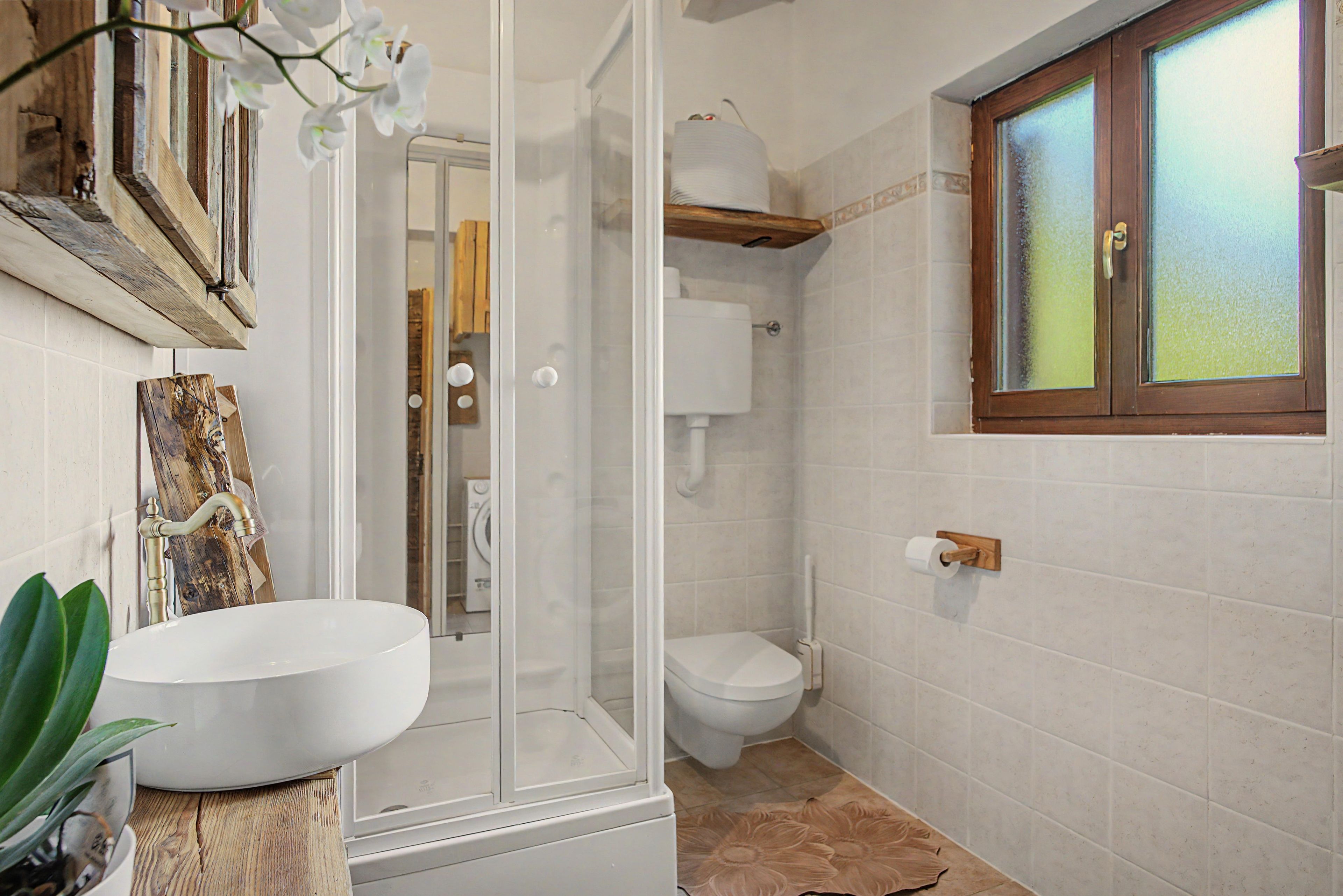 Une salle de bain avec un lavabo blanc, des toilettes et un espace douche.