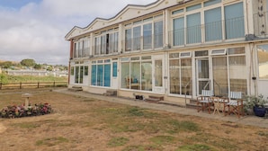 A two-story building with large windows and balconies. - 4 Kingfisher Court (Bridport)