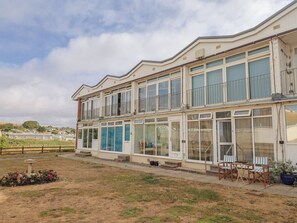 Um edifício de dois andares com grandes janelas e varandas.