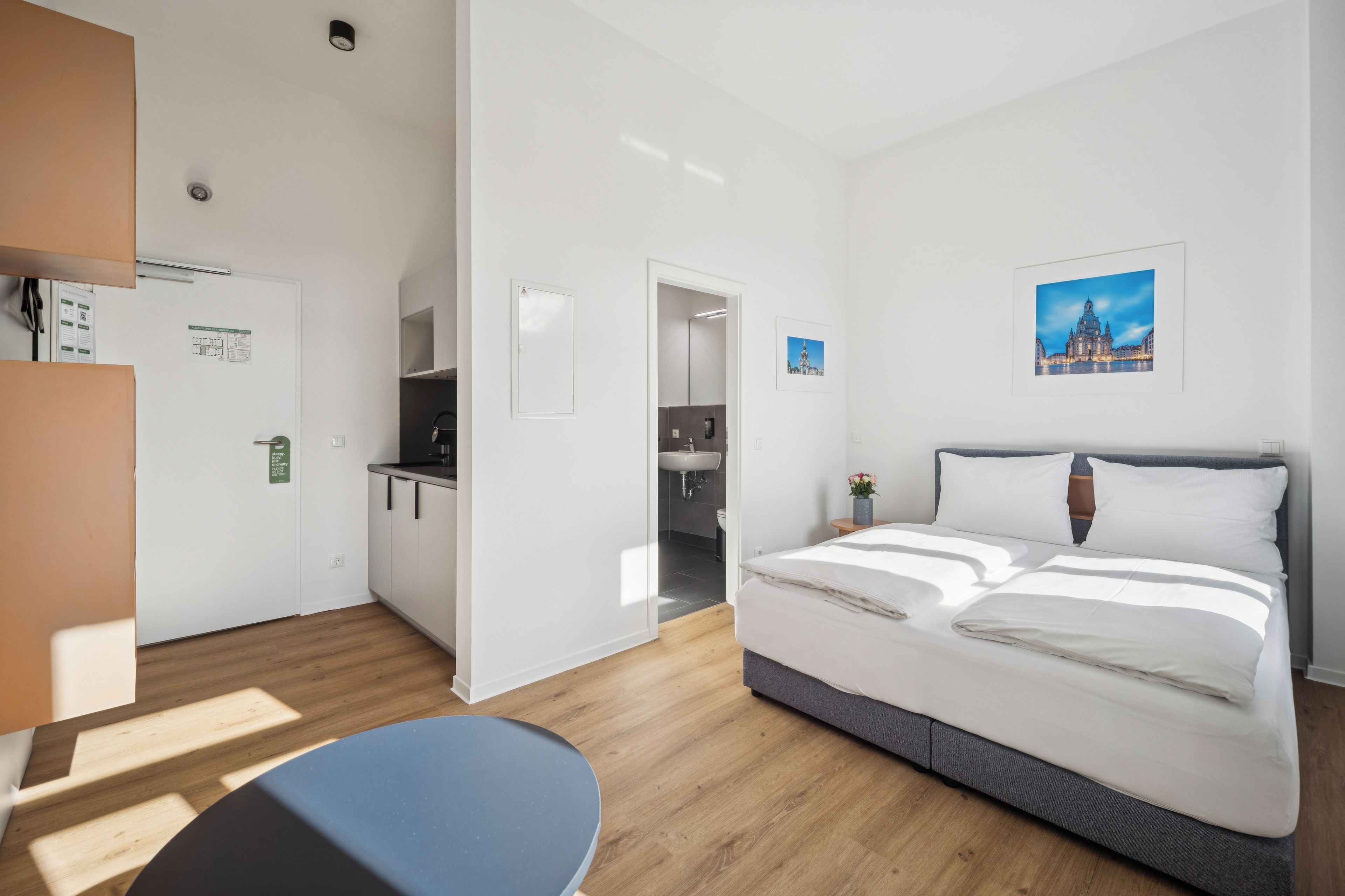 Ein Hotelzimmer mit einem Bett, einem Schreibtisch und Blick auf eine Stadtlandschaft.