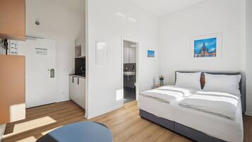 Ein Hotelzimmer mit einem Bett, einem Schreibtisch und Blick auf eine Stadtlandschaft.