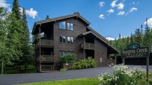 A two-story building with a balcony, surrounded by trees and a clear sky. - Spacious updated 2-bedroom townhome in Steamboat Springs perfect for getaway (Steamboat Springs)