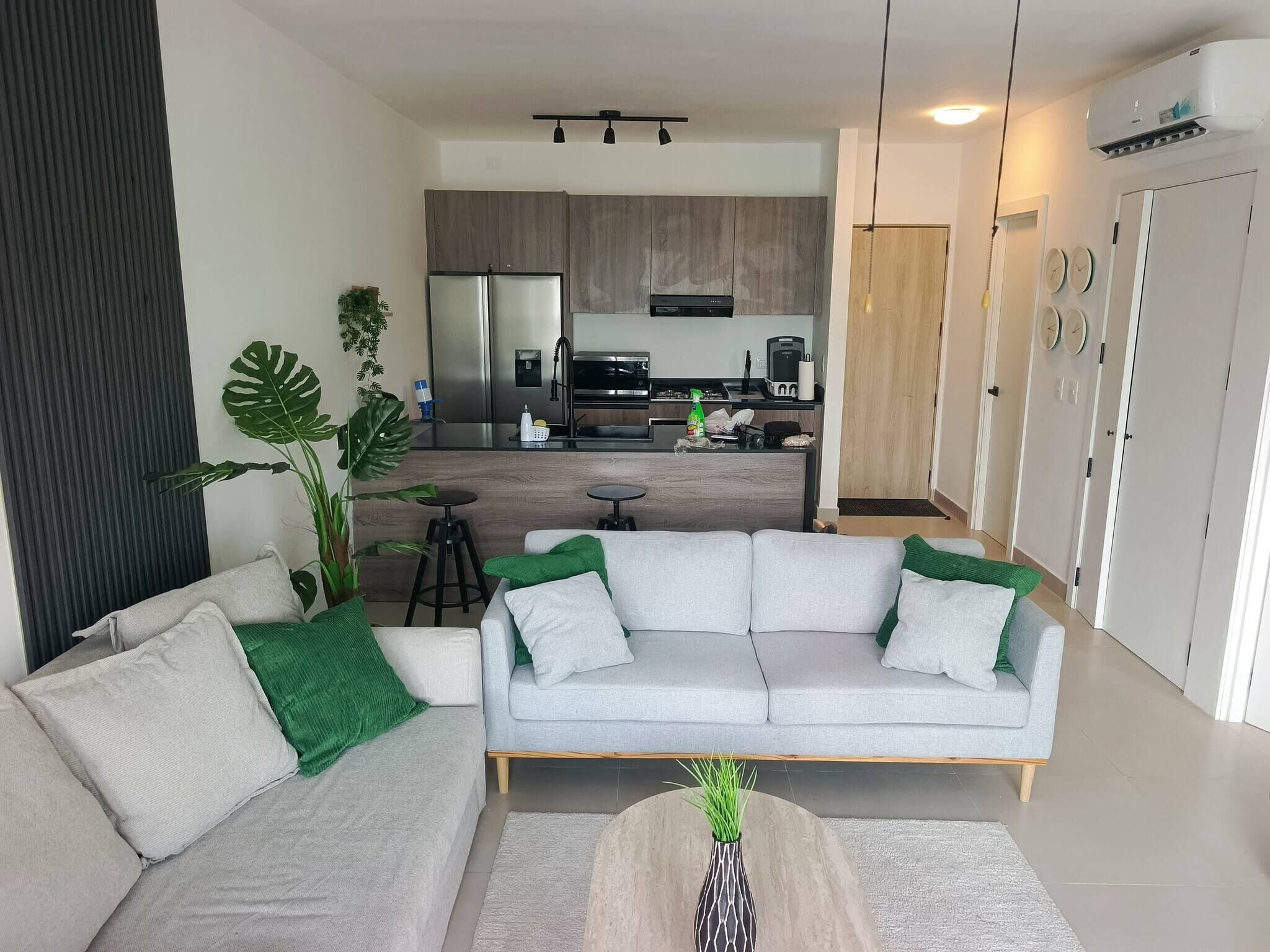 Un salon moderne avec un canapé, une table basse et une cuisine en arrière-plan.