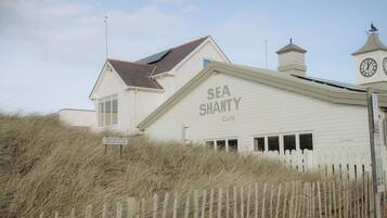 A building with a sign reading 'SEA SHANTY Café' and a clock tower.