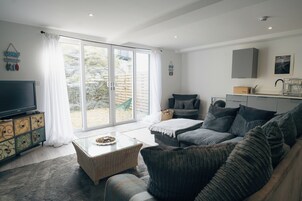 A modern living room with a sofa, a coffee table, and a television.