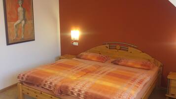 Una camera da letto con un letto in legno, una lampada a parete e un quadro.