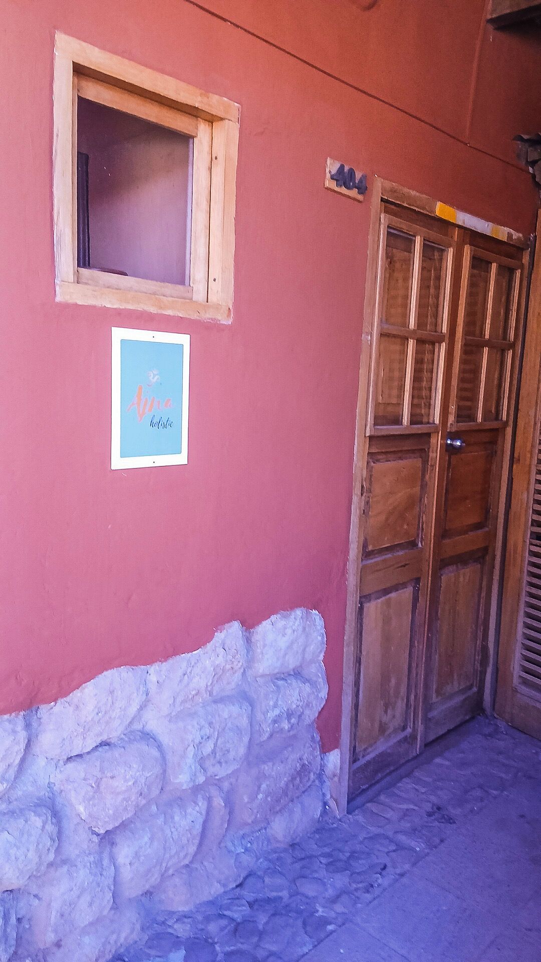A red building with a wooden door and a window.