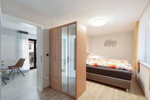 A bedroom with a bed, a wardrobe, a desk, and a chair. - Holiday Apartment "Auszeit" with Private Terrace, Garden, and Wi-Fi (Bad Liebenwerda)