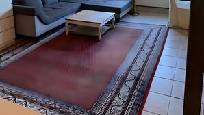Una sala de estar moderna con un sofá modular, una mesa de centro y un tapete estampado.