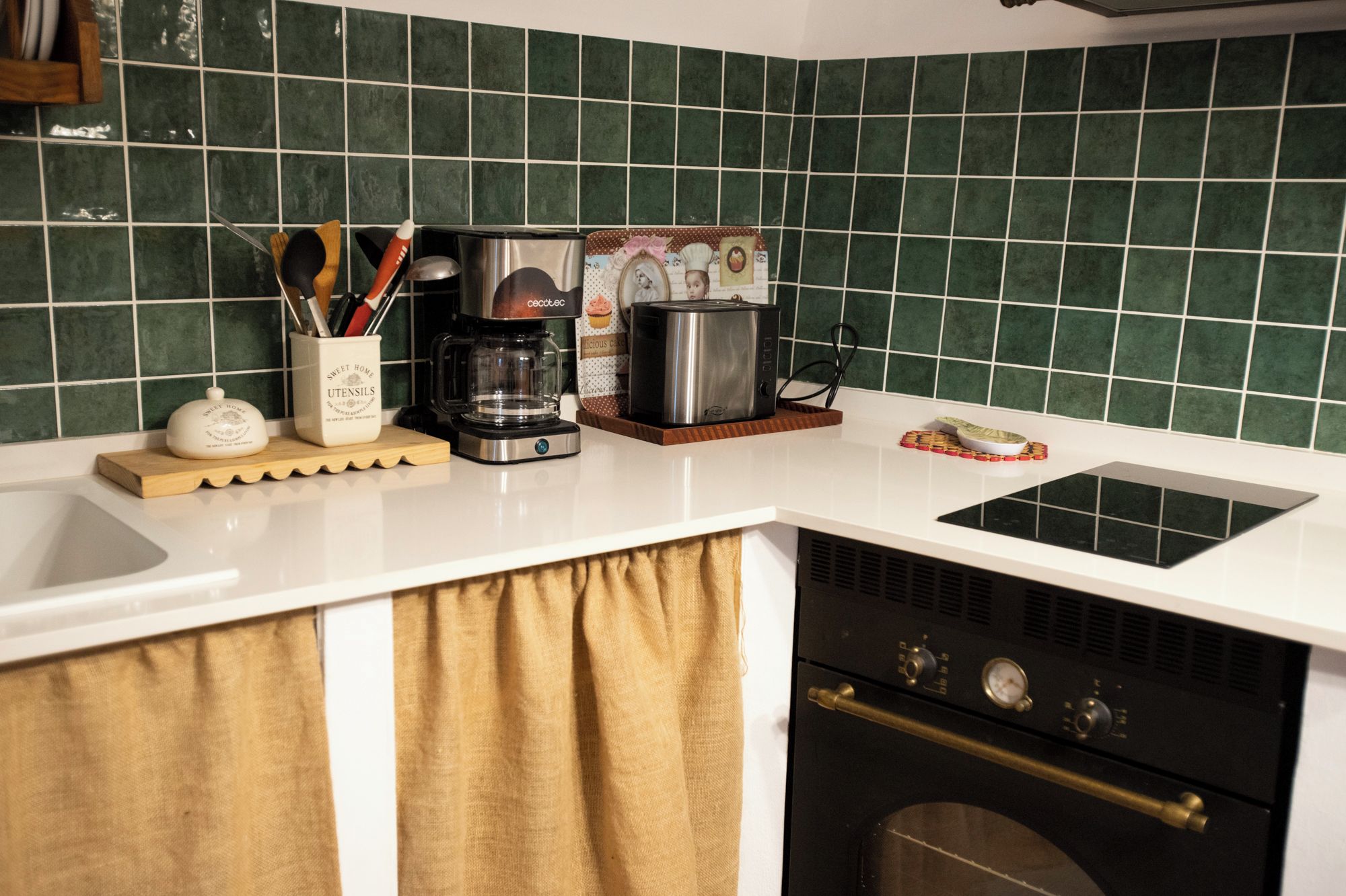 A kitchen with a coffee maker, toaster, and a decorative plate on the counter.