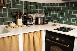 A kitchen with a coffee maker, toaster, and a decorative plate on the counter.
