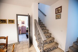 A staircase with patterned steps and a handrail, leading to an upper floor.