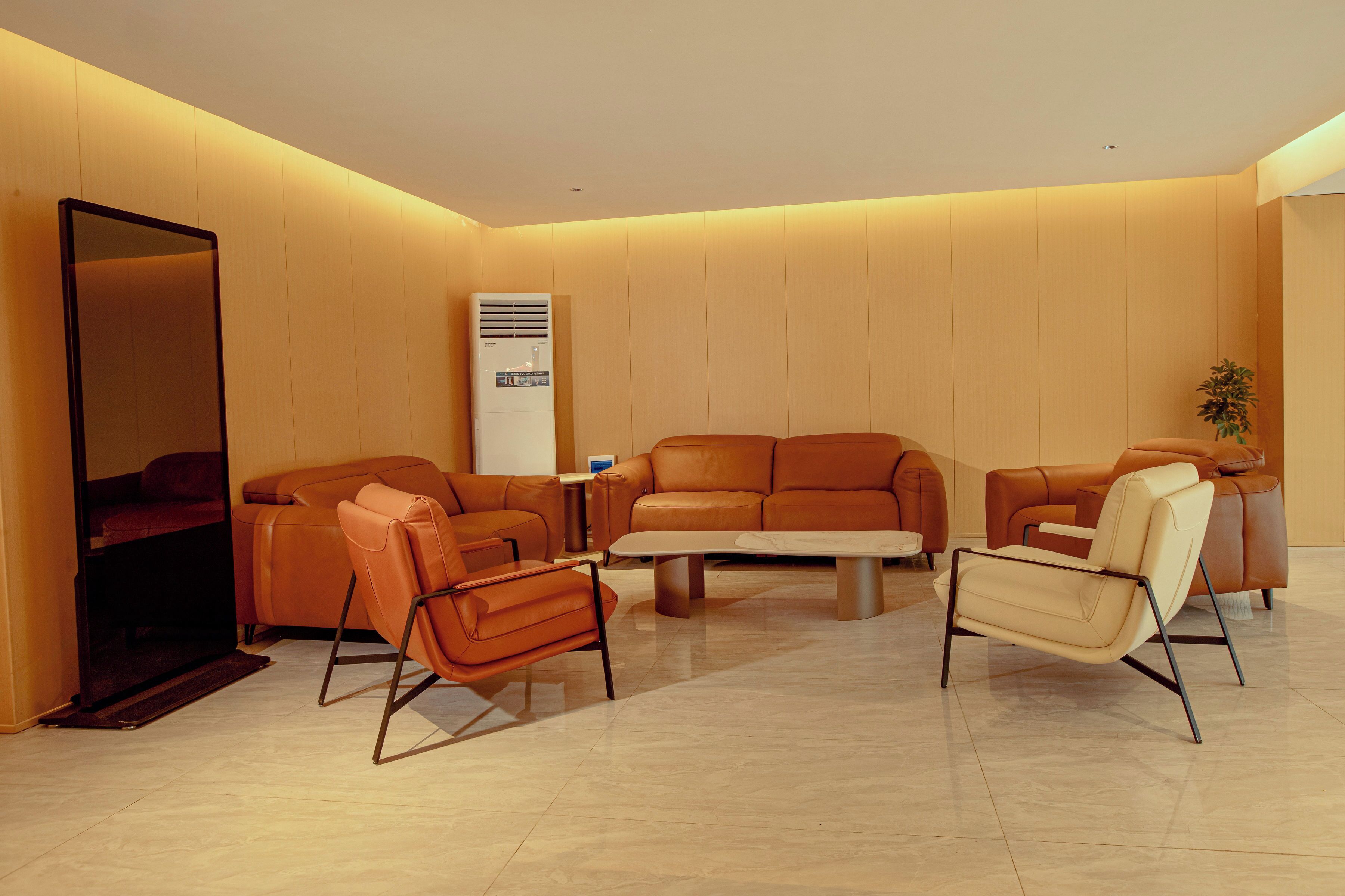 Una sala de estar moderna con un sofá, sillones y una mesa de centro.