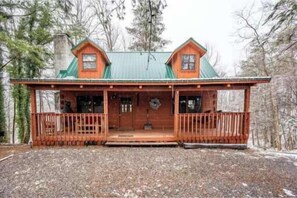 A cabin with a front porch, two chimneys, and a green roof. - Scenic Gatlinburg Cabin with Hot Tub, Game Room, & Firepit + Great Location (Gatlinburg)