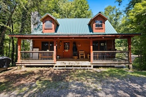 A cabin with a porch, two windows, and a chimney. - Scenic Gatlinburg Cabin with Hot Tub, Game Room, & Firepit + Great Location (Gatlinburg)