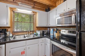 Modern kitchen amenities make meal prep a breeze - Scenic Gatlinburg Cabin with Hot Tub, Game Room, & Firepit + Great Location (Gatlinburg)