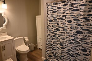 Un baño con inodoro, lavabo y mueble.