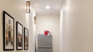 A narrow hallway with a refrigerator and three framed pictures on the wall. - "Dar Mina" in the Heart of Fes Medina (fes)