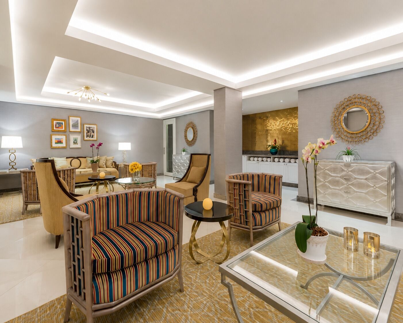 Una sala de estar moderna con un sofá, sillones, una mesa de centro y una chimenea.