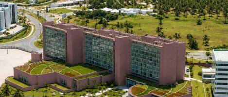 Un hotel grande con varias edificaciones, piscina y vista al océano.