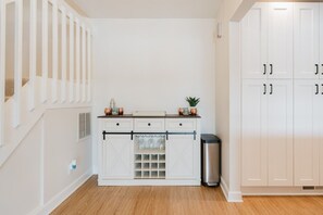 A kitchen with white cabinetry, a stainless steel trash can, and a countertop with decorative items. - Wonder Lake Extended-Stay Furnished 30-Day+ Waterfront Estate (Wonder Lake)