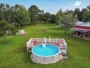 A backyard with a swimming pool, deck, and outdoor seating area. - Farm Retreat in Williston, Near Gainesville & Ocala (Williston)