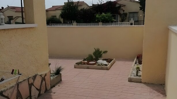 A courtyard with tiled flooring, a planter with various plants, and a white fence. - Holiday Home 'Lustigmann 2' with Private Terrace, Wi-Fi and Air Conditioning (San Fulgencio)
