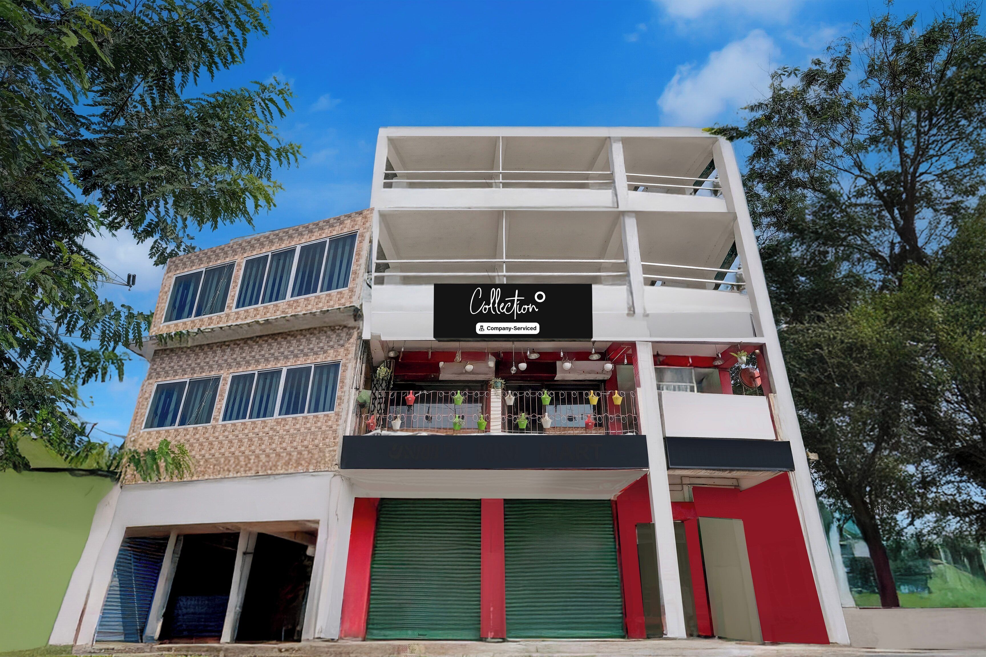A multi-story building with a storefront labeled 'Collection' and a balcony with potted plants.
