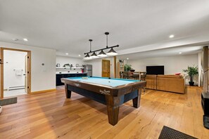A modern living room with a pool table, wooden flooring, and a dining area. - Catskills Escape w/ Hot Tub & Fireplace (Jewett)