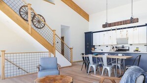 A modern interior with a staircase, dining area, and kitchen.