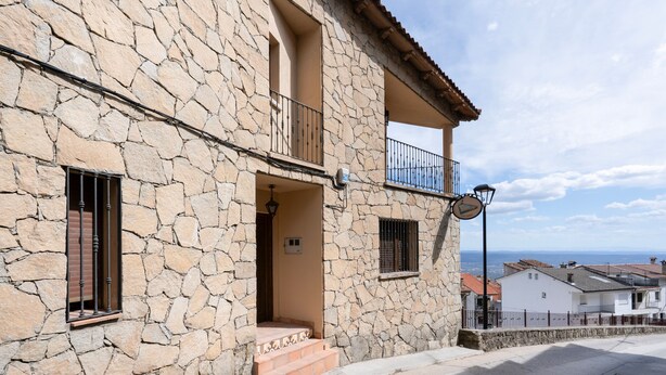 Un bâtiment en pierre doté d’un balcon, d’une petite entrée et offrant une vue sur la mer.
