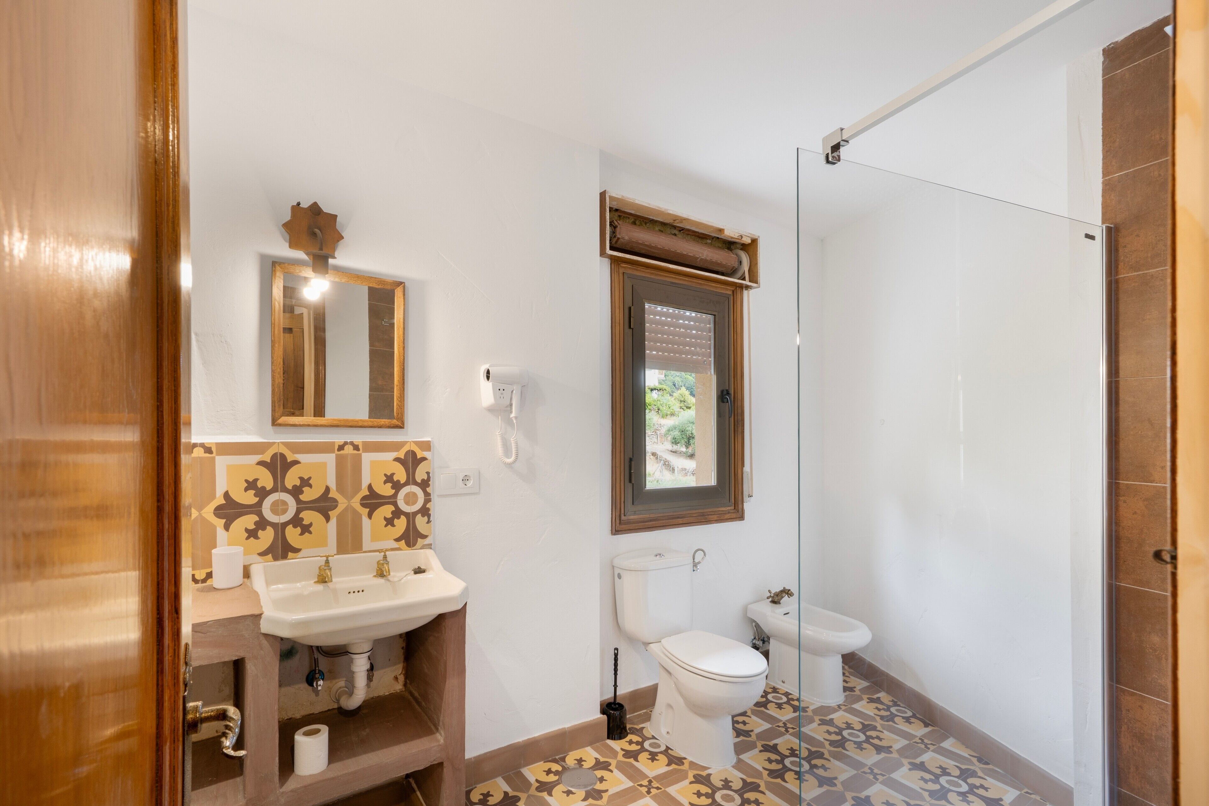 Une salle de bain avec un lavabo, des toilettes et une douche.