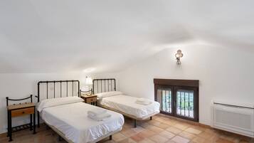 Ein Schlafzimmer mit zwei Betten, einem Nachttisch, einer Lampe und einem Fenster mit Blick.