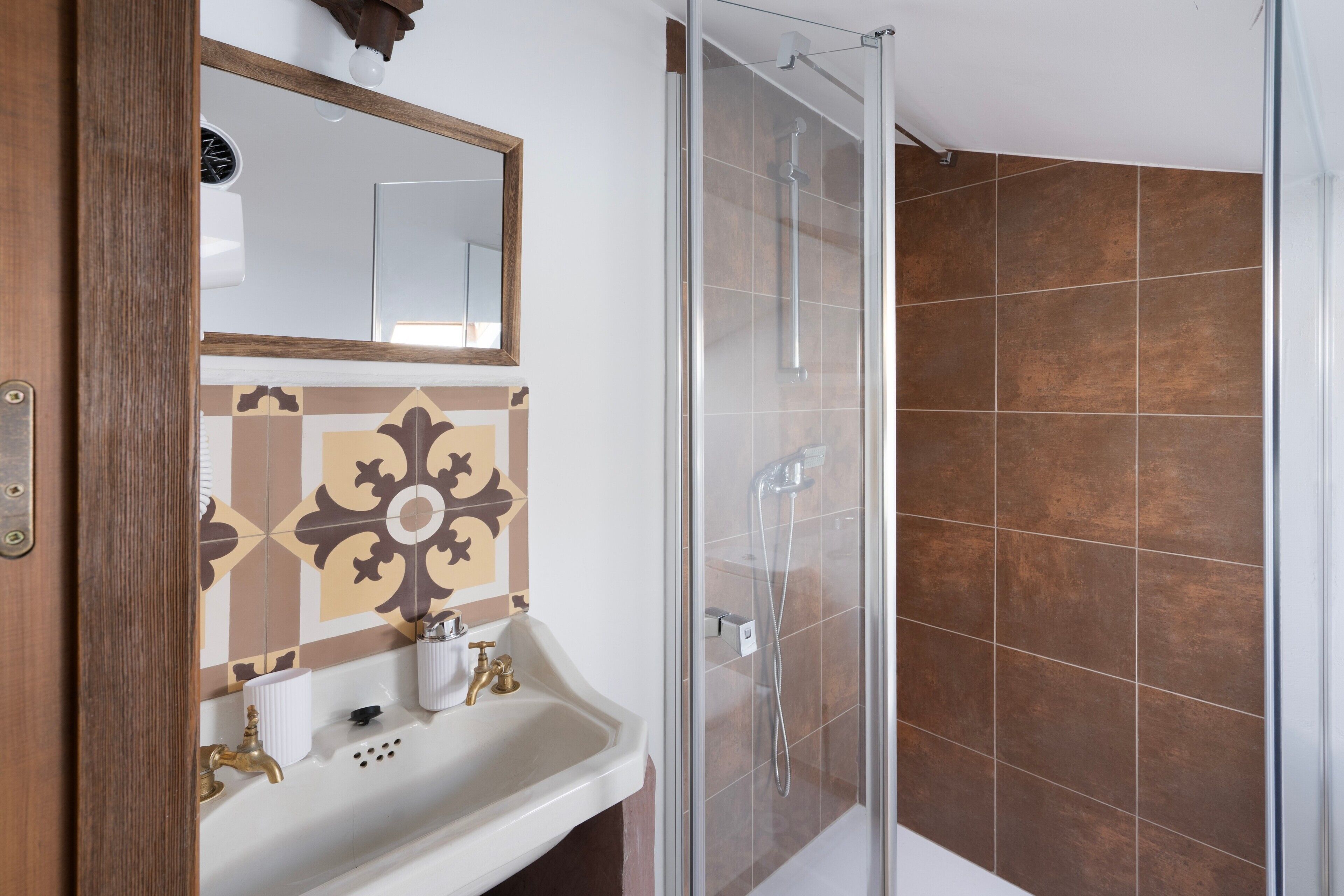 A bathroom with a shower, a sink, and a mirror.