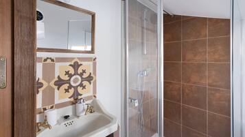 A bathroom with a shower, a sink, and a mirror.