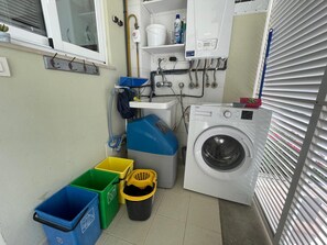 A laundry room with a washing machine, a sink, and storage bins. - Apartamento Llenaire by Mallorca North Villlas (Port de Pollença)