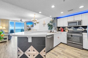 A modern kitchen with a large island, stainless steel appliances, and a view to the outside. - ⛱️Beachfront | 5 Pools | Majestic Beach Towers 2-407⛱️ (Panama City Beach)