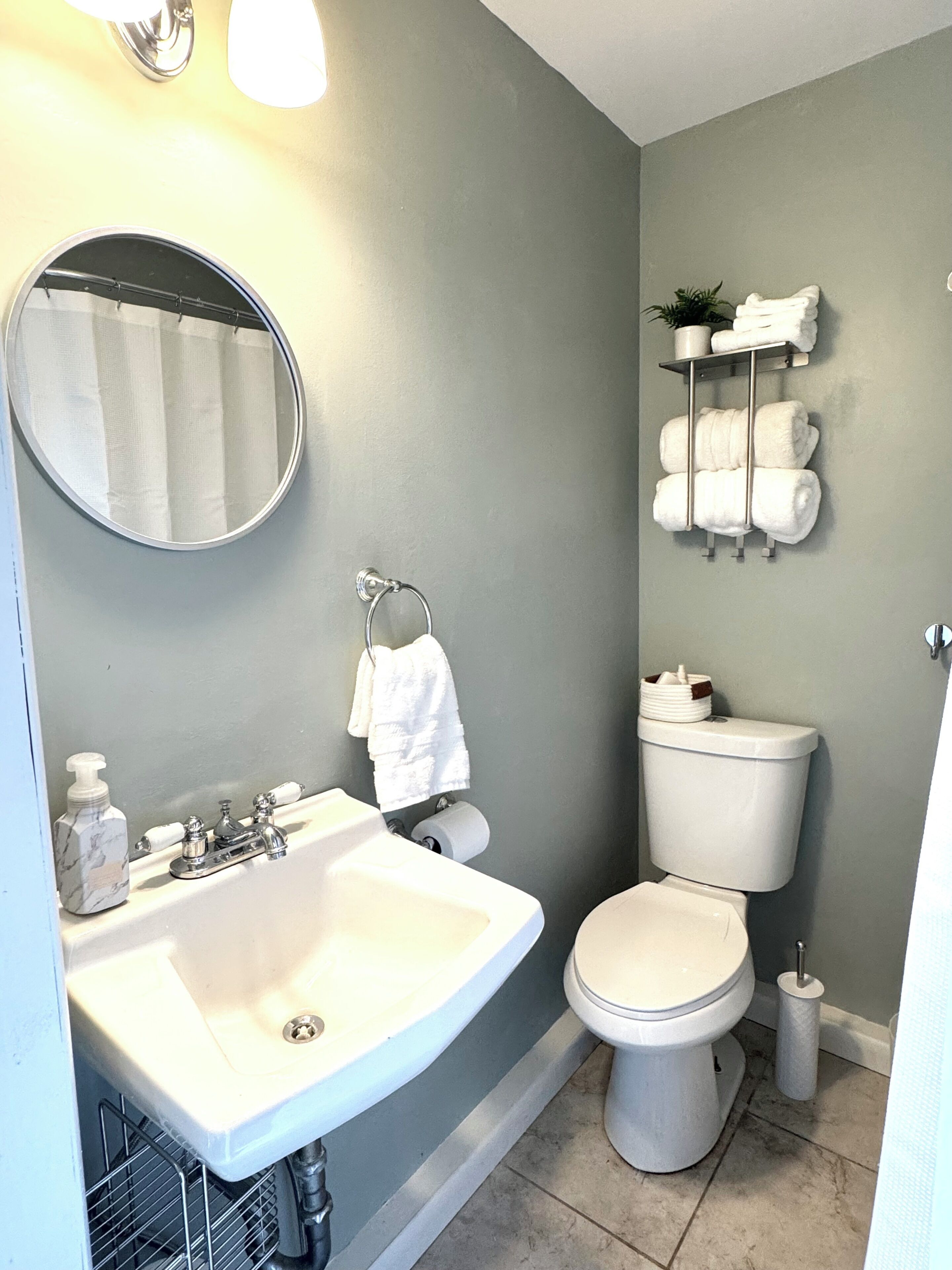 A bathroom with a sink, toilet, and towel rack.
