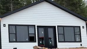 A white building with a black roof and three large windows. - NOW BOOKING FOR 2027!! (Irish Cove)
