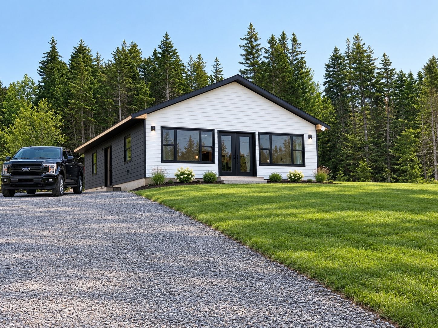 Une maison moderne à deux étages, avec une allée en gravier et une pelouse bien entretenue.