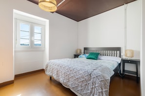 A bedroom with a bed, a nightstand, a lamp, and a window. - Tani Room with Mountain Views, Shared Terrace and WiFi (Moraime)