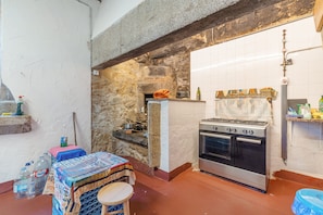 A kitchen with a stone wall, a tiled backsplash, and a gas stove. - Tani Room with Mountain Views, Shared Terrace and WiFi (Moraime)