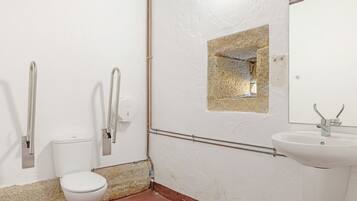 Un baño con inodoro, lavamanos y espejo.